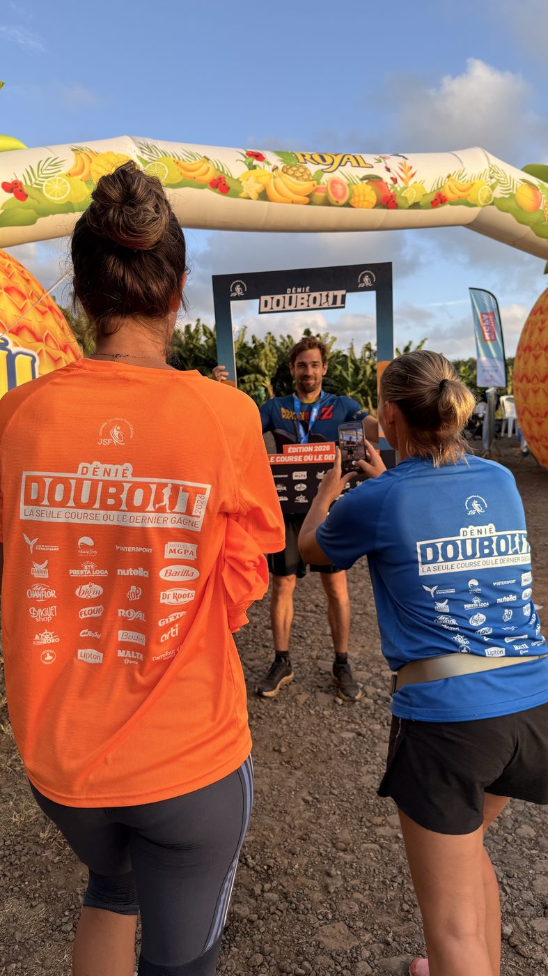 T-shirts runner orange et staff bleu devant le cadre photo